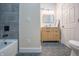 Full bathroom featuring a tiled tub, modern vanity, framed mirror, and stylish hexagon floor tiles at 5511 E University Ave, Indianapolis, IN 46219