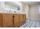 Bathroom featuring double vanity, modern lighted mirror, stylish floor tiles, and contemporary decor at 5511 E University Ave, Indianapolis, IN 46219