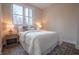 Bright bedroom featuring a comfy queen bed, large windows, hardwood-style floors, and contemporary decor at 5511 E University Ave, Indianapolis, IN 46219