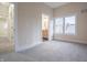 A bright bedroom with neutral walls, carpeted floors and a view into bathroom at 5511 E University Ave, Indianapolis, IN 46219