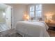 Cozy bedroom featuring a comfy queen bed, large windows, hardwood-style floors, and contemporary decor at 5511 E University Ave, Indianapolis, IN 46219