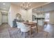 Bright dining room features a modern chandelier, hardwood-style floors, and an open layout to the kitchen at 5511 E University Ave, Indianapolis, IN 46219