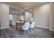 Bright dining room features a modern chandelier, hardwood-style floors, and an open layout to the living room at 5511 E University Ave, Indianapolis, IN 46219