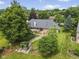 Aerial view showcasing the home's beautiful landscaping, mature trees, and backyard stone path at 5591 Royal Troon Way, Avon, IN 46123