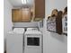 Functional laundry area with washer, dryer, and overhead cabinets at 5591 Royal Troon Way, Avon, IN 46123