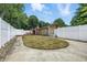 Large backyard fully enclosed by a white fence with an area of short manicured lawn and a concrete patio at 5982 Oak Hill East Dr, Plainfield, IN 46168