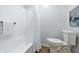 All-white bathroom featuring a tub with shower, a modern commode, and artwork at 5982 Oak Hill East Dr, Plainfield, IN 46168