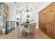 Dining room features a stone wall, chandelier, wood floors, and sliding closet doors at 5982 Oak Hill East Dr, Plainfield, IN 46168