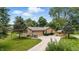 Tan single-story home with stone accents, attached garage, mature trees, and a well-manicured lawn at 5982 Oak Hill East Dr, Plainfield, IN 46168