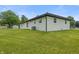 View of the backyard features a well-maintained lawn and a freshly painted white brick home at 6609 Cordova Ct, Indianapolis, IN 46221