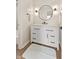 Modern bathroom vanity features a round mirror and sleek fixtures, complemented by neutral tones and updated finishes at 6609 Cordova Ct, Indianapolis, IN 46221