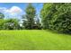 Spacious backyard featuring lush green lawn, mature trees, shed, trampoline and a playset at 6655 Teeters Ln, Martinsville, IN 46151