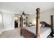 The spacious bedroom features neutral carpeting and a four-poster bed with views to the Primary bathroom at 6655 Teeters Ln, Martinsville, IN 46151