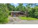 Charming front exterior with brick and wood accents, covered porch, mature trees, and driveway at 6655 Teeters Ln, Martinsville, IN 46151