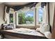 A comfortable window seat is adorned with plush cushions and overlooks a charming residential neighborhood at 6655 Teeters Ln, Martinsville, IN 46151