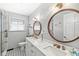 Bright bathroom with double sinks, white countertops, and geometric-patterned floor at 7125 Chandler Dr, Indianapolis, IN 46217