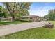 Property featuring a large driveway, mature trees, and well-maintained landscaping, offering ample parking at 7125 Chandler Dr, Indianapolis, IN 46217