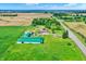 An aerial view showcasing a farm with a barn, house with a pool, surrounded by lush green fields and mature trees at 7165 W State Road 252 W Rd, Edinburgh, IN 46124