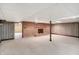 Open basement space with brick fireplace and wood paneling, offering a cozy and versatile area at 7165 W State Road 252 W Rd, Edinburgh, IN 46124