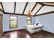Bedroom with vaulted ceiling, rustic chandelier, hardwood floors, and ample natural light at 7165 W State Road 252 W Rd, Edinburgh, IN 46124