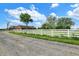 A sprawling estate featuring a long driveway, white fence, and mature trees for enhanced privacy and curb appeal at 7165 W State Road 252 W Rd, Edinburgh, IN 46124