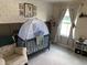 Charming Bedroom with woodland themed wallpaper, a comfortable chair, and ample natural light at 7270 W Stone Pass, New Palestine, IN 46163