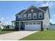 Charming two-story home with gray siding, white trim, a two-car garage, and a well-manicured lawn at 7270 W Stone Pass, New Palestine, IN 46163