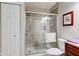 Tiled bathroom featuring glass-enclosed shower and cherry wood vanity at 741 Chestnut Ln, Brownsburg, IN 46112