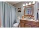 Charming bathroom with a wood vanity, framed mirror, and a shower with a blue shower curtain at 741 Chestnut Ln, Brownsburg, IN 46112