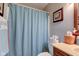Neutral bathroom with a wood vanity, framed mirror, and a shower with a patterned shower curtain at 741 Chestnut Ln, Brownsburg, IN 46112