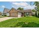 Inviting one-story home featuring a brick facade, attached garage, a vibrant lawn, and cheerful flower beds at 741 Chestnut Ln, Brownsburg, IN 46112