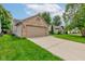 Attached two-car garage with brick and siding, with a concrete driveway and green lawn at 741 Chestnut Ln, Brownsburg, IN 46112