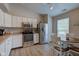 Bright kitchen featuring white cabinets, stainless steel appliances, a breakfast table, and modern wood flooring at 741 Chestnut Ln, Brownsburg, IN 46112