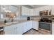 Well-lit kitchen boasting white cabinets, stainless steel appliances, and an open view into adjacent spaces at 741 Chestnut Ln, Brownsburg, IN 46112