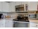 Bright kitchen features stainless steel appliances including microwave, oven, and white cabinets at 741 Chestnut Ln, Brownsburg, IN 46112