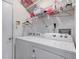 Functional laundry room with a white washer and dryer and shelving for storage at 741 Chestnut Ln, Brownsburg, IN 46112