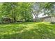 Expansive backyard featuring lush green grass and mature trees offering shade at 7651 Sherry Ln, Brownsburg, IN 46112