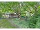 Landscaped backyard featuring a charming shed, rustic swing, and mature trees providing ample shade at 7651 Sherry Ln, Brownsburg, IN 46112