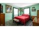 View of a bedroom featuring a bed with red bedding, green walls, and natural light from the windows at 7651 Sherry Ln, Brownsburg, IN 46112