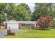 Charming single-story brick home featuring an attached garage and a well-maintained front yard and patriotic decor at 7651 Sherry Ln, Brownsburg, IN 46112
