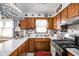 Well-lit kitchen boasting wood cabinetry, bright countertops, and modern appliances, creating a practical and appealing space at 7651 Sherry Ln, Brownsburg, IN 46112