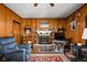 Cozy living room featuring a brick fireplace, wood paneling, a comfortable chair, and rustic decor at 7651 Sherry Ln, Brownsburg, IN 46112