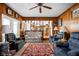 Spacious living room featuring wood-paneled walls, comfortable seating, and a view into the kitchen at 7651 Sherry Ln, Brownsburg, IN 46112