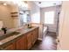 Stylish bathroom featuring a double sink vanity, wood-look flooring, and tiled shower at 7710 Samuel Dr, Indianapolis, IN 46259