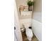 Quaint powder room featuring wood-look flooring, wainscotting, and decorative shelf accents at 7710 Samuel Dr, Indianapolis, IN 46259