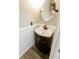 Well-lit half bathroom with a dark wood vanity and decorative mirror at 7710 Samuel Dr, Indianapolis, IN 46259