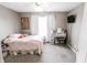 A bright bedroom with a desk, gray carpet, and soft pink bedding at 7710 Samuel Dr, Indianapolis, IN 46259