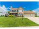 Traditional two-story home boasts a well-maintained lawn, brick facade, and an attached two-car garage at 7710 Samuel Dr, Indianapolis, IN 46259