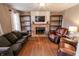 Comfortable living room features a brick fireplace, mantle, hardwood floors, and ample seating at 7710 Samuel Dr, Indianapolis, IN 46259
