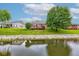 A scenic backyard features a private deck overlooking a serene pond and lush landscaping at 7911 Bentley Commons Dr, Indianapolis, IN 46259